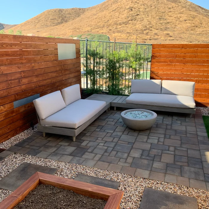 Outdoor lounge with fire pit, daybeds and wood privacy wall