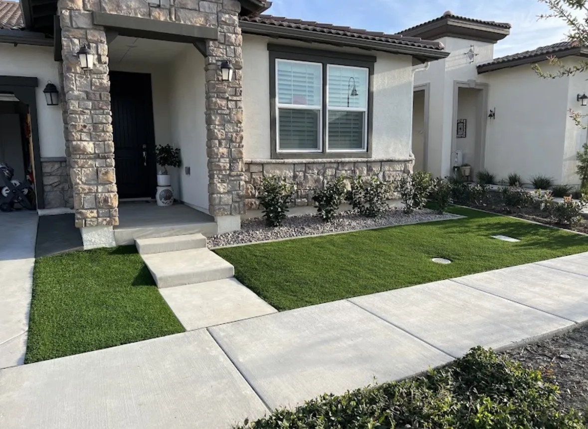 Front yard artificial turf with modern concrete step pads