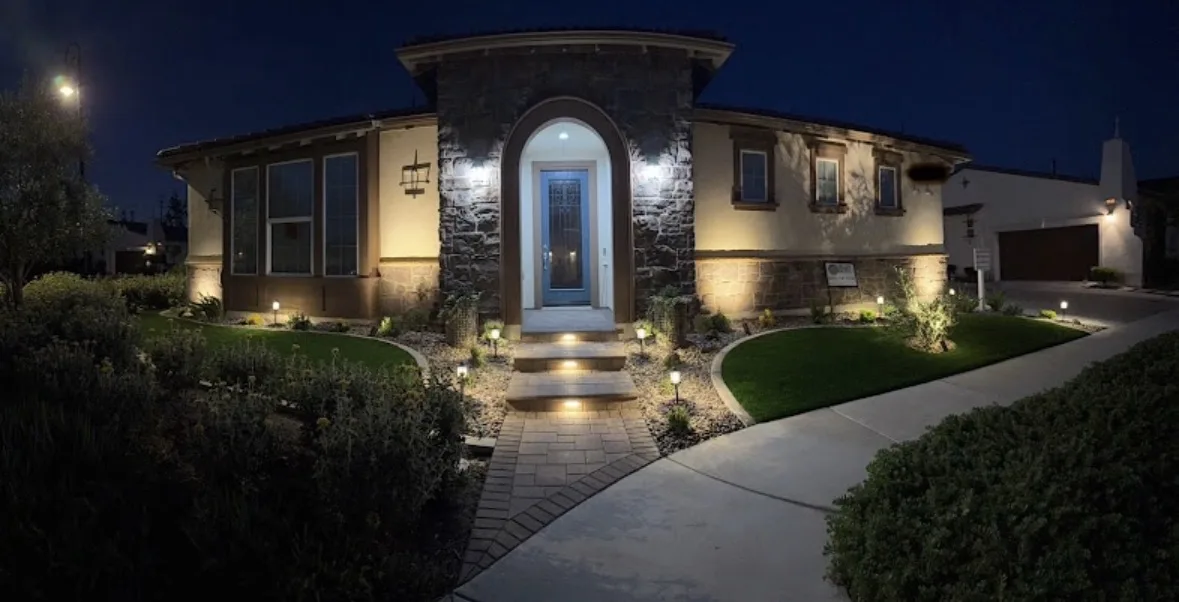 Low-voltage landscape lighting illuminating a paver entry walkway and front yard at night