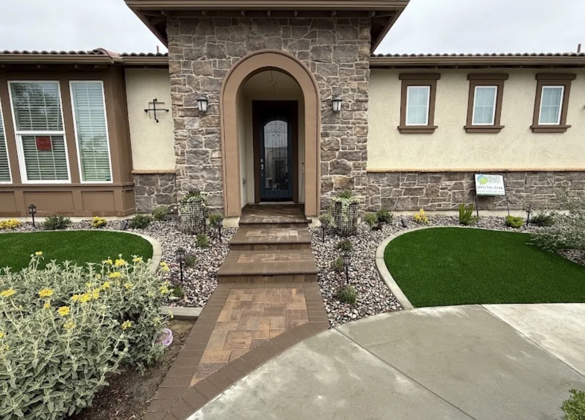 Paver entry walkway with artificial turf and rock planting beds