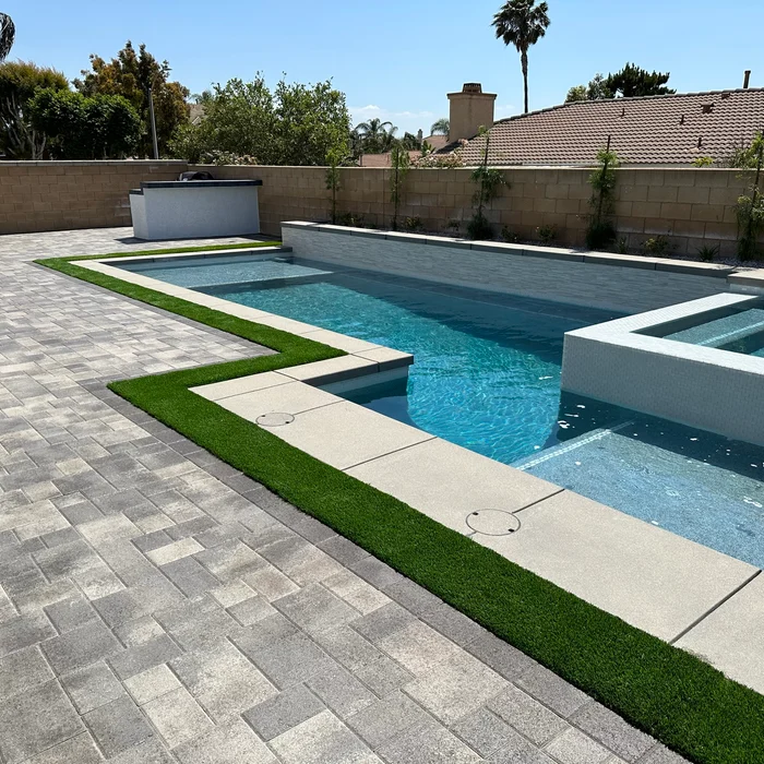 Completed backyard with pool, paver deck and artificial turf by Valley Pacific Landscape