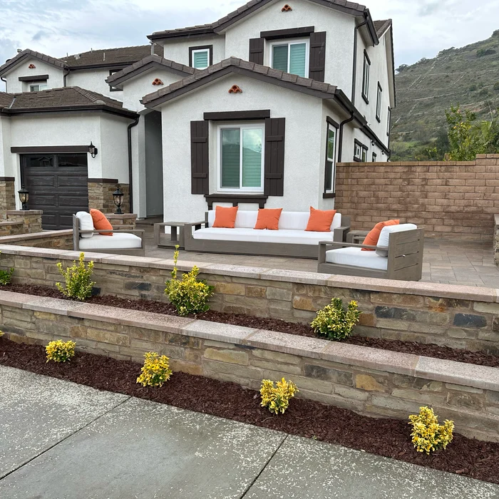Stone seating and retaining wall with front patio by Valley Pacific Landscape
