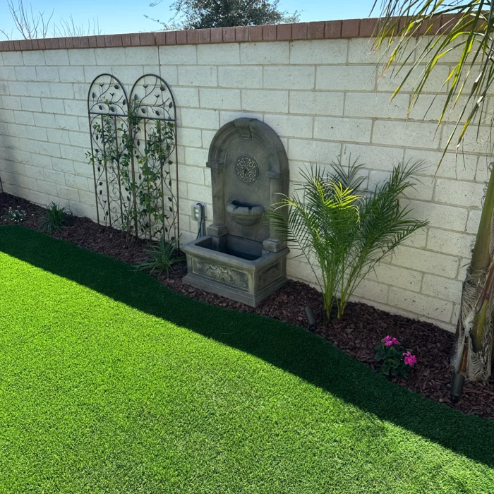 Artificial turf lawn with garden wall fountain
